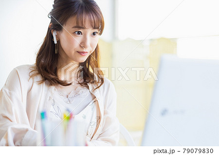 自宅のリビングルームでリモートワークをしている女性 79079830