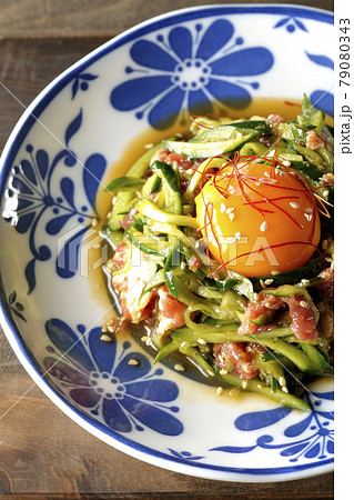 卵黄や糸唐辛子やいり胡麻が乗っている胡瓜と生ハムユッケを俯瞰撮影 卵黄や糸唐辛子やいり胡麻が乗っている胡瓜と生ハムユッケを俯瞰撮影 79080343