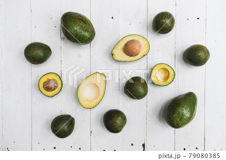 Whole and halved avocado on wooden table Whole and halved avocado on wooden table 79080385