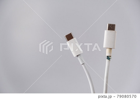 Close-up of a torn and intact type C mobile phone charging wire. Close-up of a torn and intact type C mobile phone charging wire. 79080570