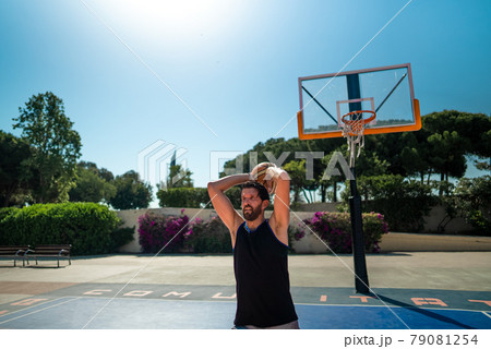 A male basketball player gives a pass to another player 79081254