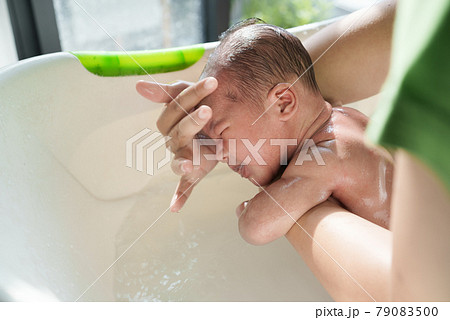 new born infant taking a bath in the morning new born infant taking a bath in the morning 79083500