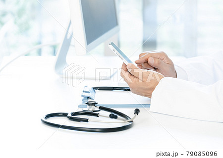 スマホを操作する医師の手元 79085096