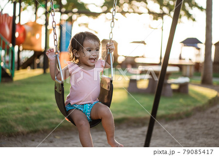 Asian girl playing on a swing and having fun in park 79085417