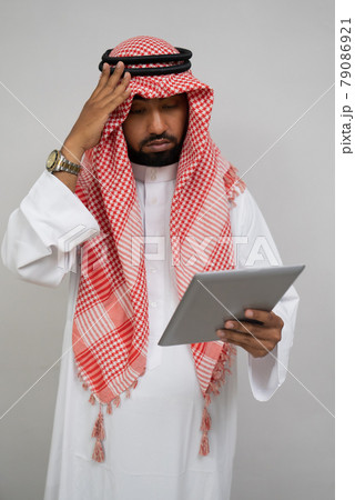 an arab in a turban is dizzy while using a pad 79086921