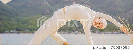 BANNER, LONG FORMAT Kundalini yoga woman in white clothes and turban practices yoga kundalini on the background of the sea, mountains and sunset. Fighting face painting of the Indians shows her inner BANNER, LONG FORMAT Kundalini yoga woman in white clothes and turban practices yoga kundalini on the background of the sea, mountains and sunset. Fighting face painting of the Indians shows her inner 79087090