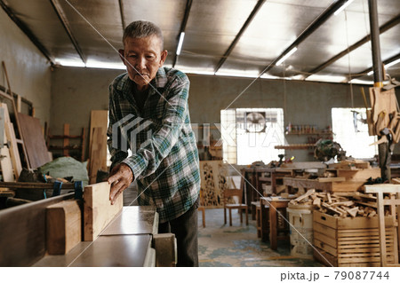 Experienced Carpenter Using Bench Top Jointer 79087744