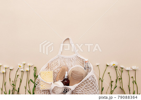 Eco friendly beige flat lay with shopping bag, flowers, bath accessories Eco friendly beige flat lay with shopping bag, flowers, bath accessories 79088364