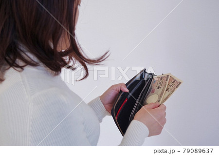 財布からお金を出す女性 79089637