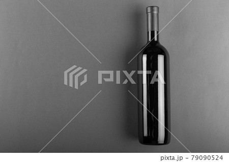 Corked bottle of red wine on a gray background. Alcoholic drink. Corked bottle of red wine on a gray background. Alcoholic drink. 79090524
