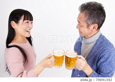 ビールで乾杯する中年男女夫婦 79091392