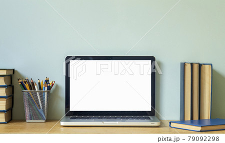 Home office desk table background. Empty laptop screen pc on the wooden table with books for work or study. 79092298