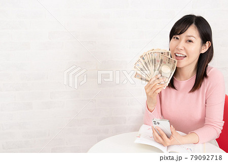 株やFX投資の勉強をして、ぼろ儲けして札束を握る女性 株やFX投資の勉強をして、ぼろ儲けして札束を握る女性 79092718