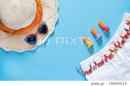 Summer composition. Sunglasses, hat, white shorts and nail polish on a light blue background with copy space. Vacation concept. flat lay. 79094024
