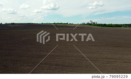Aerial drone view flight over huge plowed field and blue sky. Aerial drone view flight over huge plowed field and blue sky. 79095229