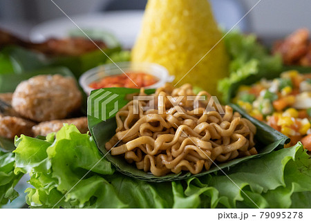 nasi tumpeng. indonesian cuisine yellow rice on banana leaf 79095278