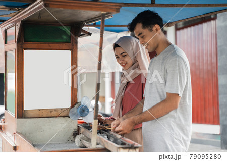 two seller preparing food on their food stall selling traditional chicken satay 79095280