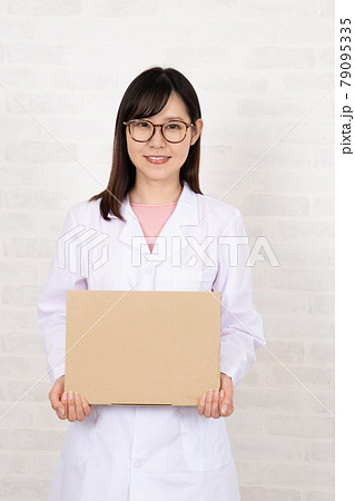 ボードを持つメガネをかけた白衣の若い女性 79095335