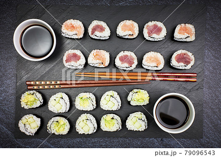 Presentation on a slate of seafood sushi and vegetable sushi with chopsticks. Oriental food Presentation on a slate of seafood sushi and vegetable sushi with chopsticks. Oriental food 79096543