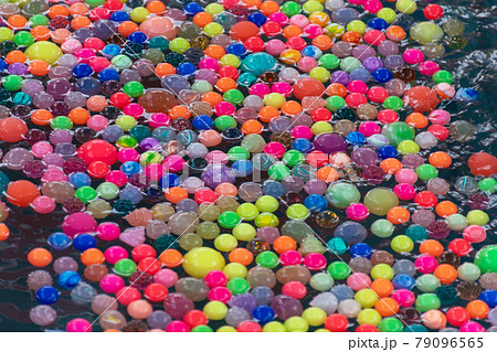 夏祭りのスーパーボールすくい 水に浮かぶカラフルなゴムボールの写真素材