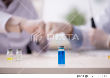 Two male chemists working at the lab during pandemic 79099749
