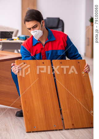 Young male carpenter working in the office during pandemic 79100060