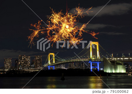夏イメージ お台場のレインボーブリッジをバックに線香花火をする 夏の思い出づくり の写真素材