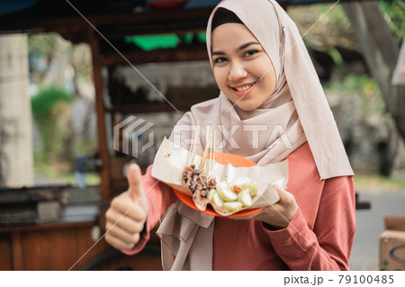 happy customer enjoying chicken satay and showing thumb up 79100485