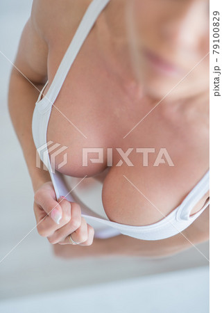 Sexy woman seductively pulls off a white top - Stock Photo