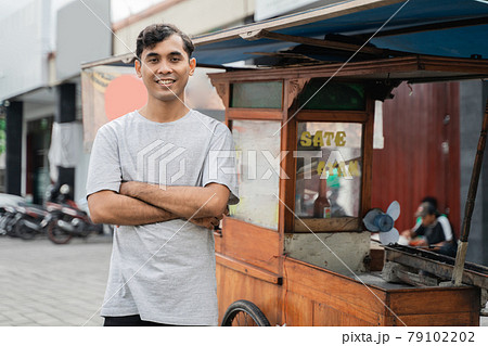 man street food seller of chicken satay with food cart selling sate ayam. man street food seller of chicken satay with food cart selling sate ayam. 79102202