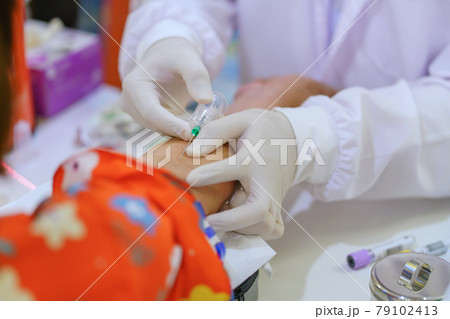 Nurse collecting a blood from patient in hospital 79102413