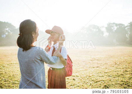 mother fixing her daughter primary school student uniform mother fixing her daughter primary school student uniform 79103105