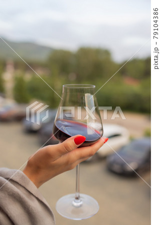 Male hand holding glass with wine on blurred natural background. 79104386