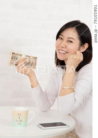 スマホ情報で大金を手に入れ札束を握る若い女性 79105901