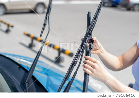 Faceless woman changing car windshield wipers. 79106416