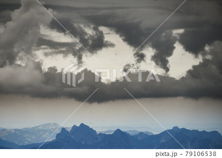 View over the Austrian and Swiss Alps from the Zugspitze, with a dramatic sky over the rugged mountains. 79106538