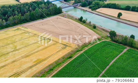 Aerial view of a canal that runs through fields, meadows and arable land in the flat landscape of northern Germany. 79106662