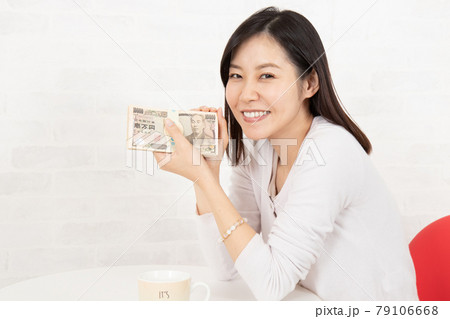 大金(札束100万円)を手に入れた若い女性 大金(札束100万円)を手に入れた若い女性 79106668