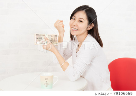 大金(札束100万円)を手に入れた若い女性 大金(札束100万円)を手に入れた若い女性 79106669