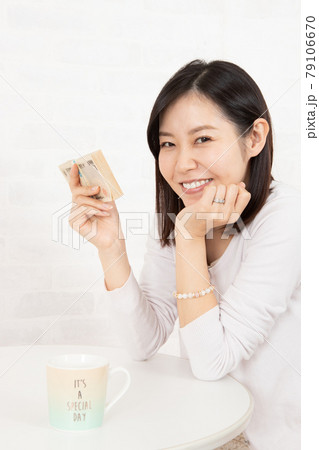 大金(札束100万円)を手に入れた若い女性 大金(札束100万円)を手に入れた若い女性 79106670