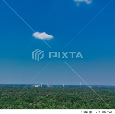 Horizontal aerial view to the horizon with blue sky, much copy space, a small cloud and windmills 79106758