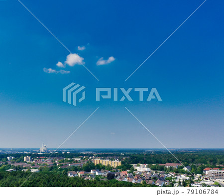 Aerial view of a distant city with a high blue sky and a small white cloud 79106784