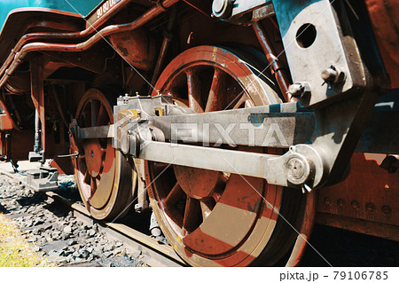 Close-up of the drive wheels and the drive rod of a historic steam locomotive 79106785