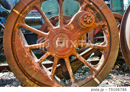 Detail of an old rusty weathered iron red wheel of a historic locomotive 79106786