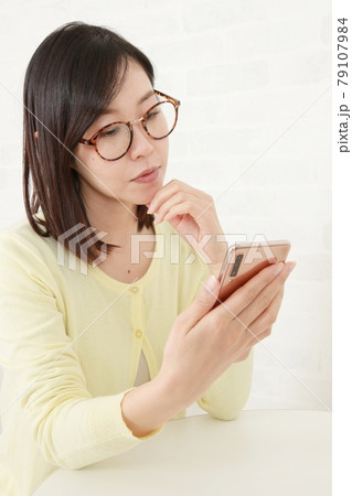 若いメガネ女子とスマートフォン 79107984