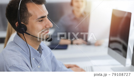 Call center. Group of casual dressed operators at work. Adult businessman in headset at customer service office. Telesales in business Call center. Group of casual dressed operators at work. Adult businessman in headset at customer service office. Telesales in business 79108727