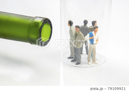 miniature people. man addicted to alcohol on the background of a bottle of wine and a glass. miniature people. man addicted to alcohol on the background of a bottle of wine and a glass. 79109921