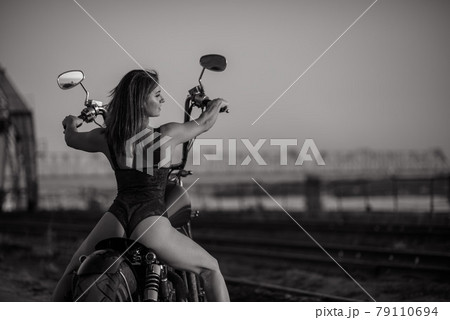 Red-haired woman in sexy lingerie in high heels sits on a motorcycle. Attractive red-haired girl sits on a motorcycle at sunset Red-haired woman in sexy lingerie in high heels sits on a motorcycle. Attractive red-haired girl sits on a motorcycle at sunset 79110694