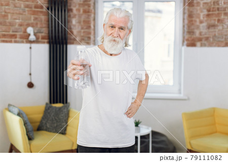Elderly man holding bottle of water after workout 79111082
