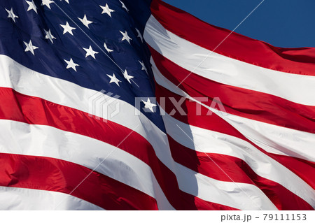 American Flag Waving In Wind Against a Deep Blue Sky. 79111153